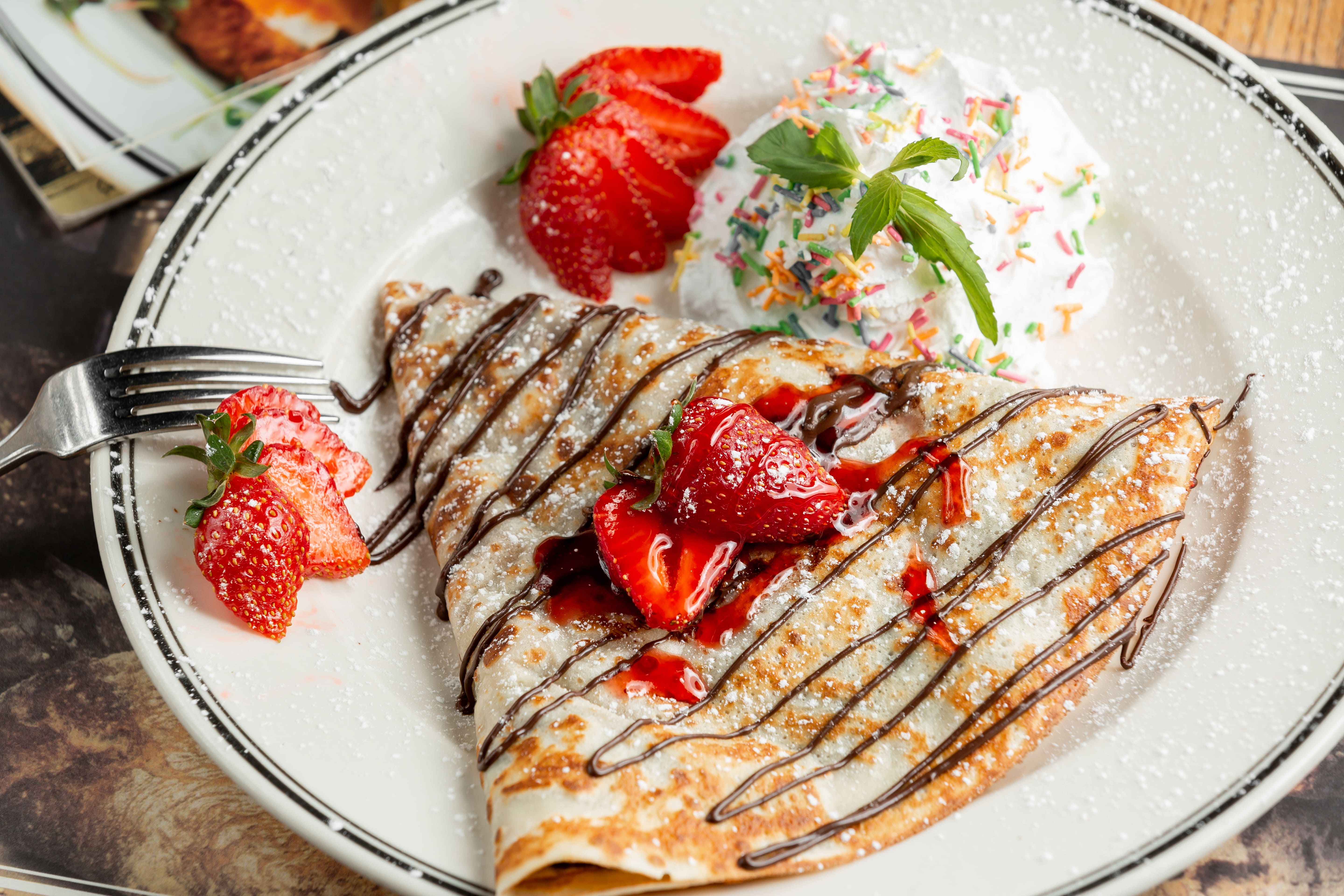Crêpe topped with chocolate and strawberries